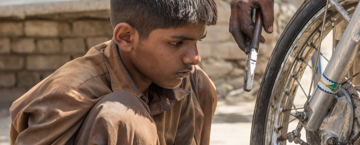 Poor child looking at a bicycle